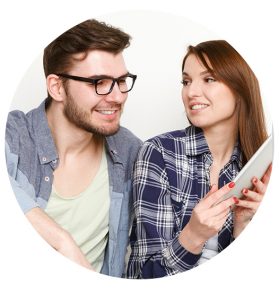 couple reading over a tablet smiling and showing what they found to eachother